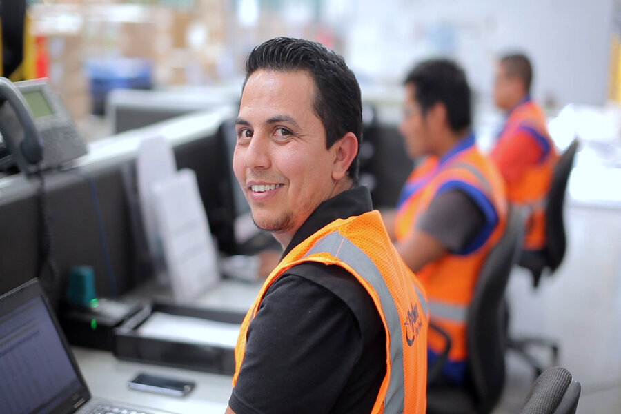 employee at a desk in front of a laptop