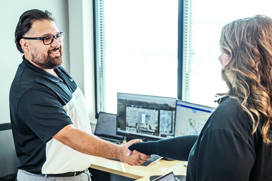 two  persons shaking hands in office